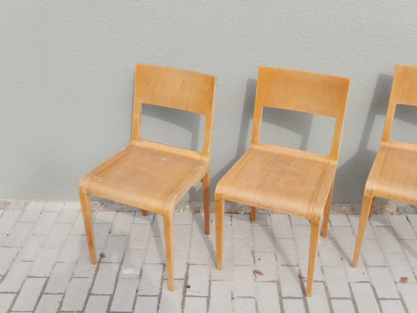 Schrägansicht des kompletten 4er-Satzes Hellerau-Stühle. Die Aufnahme zeigt die harmonischen Proportionen, die leicht gebogene Rückenlehne sowie die hochwertige Verarbeitung der formverleimten Holzkonstruktion nach dem Entwurf von Erich Menzel.
