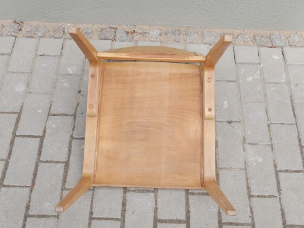 Detailaufnahme der Unterseite eines Hellerau-Stuhls. Sichtbar sind die sauber verarbeitete Konstruktion, die stabile Verbindung der Sitzfläche mit dem Gestell sowie die hochwertige handwerkliche Ausführung der Deutschen Werkstätten Hellerau.
