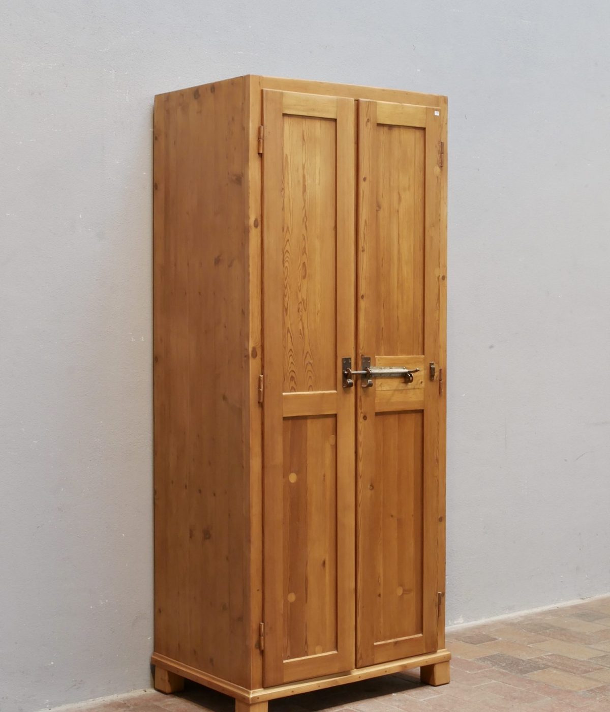 Schmale Seitenansicht des restaurierten historischen Weichholz-Spinds mit originalen Holzverbindungen und gewachster Oberfläche.