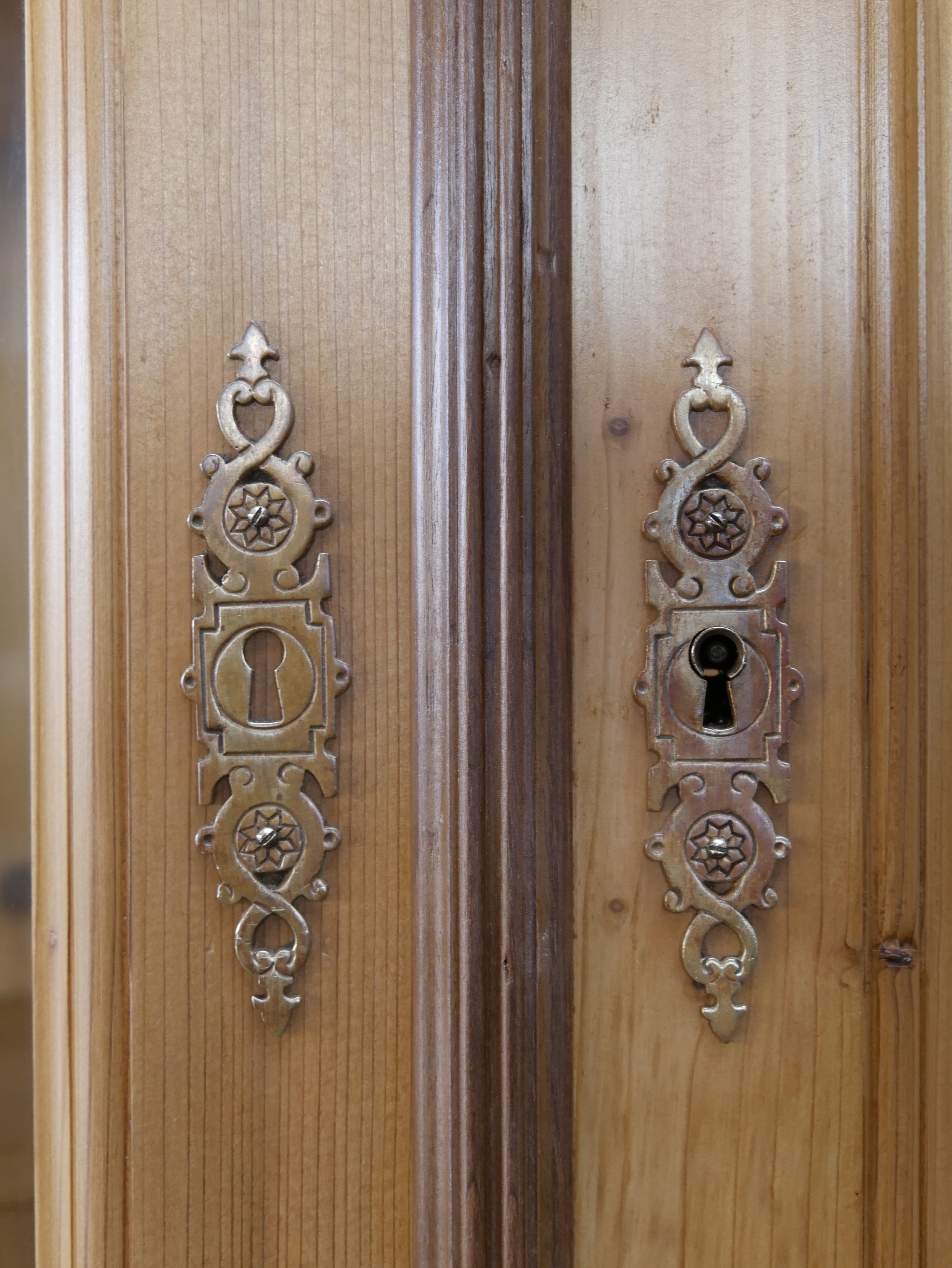 Detailansicht des originalen Stangenschlosses mit reich verziertem Beschlag an der Tür der antiken Bibliotheksvitrine. Das historische Schloss ist ein typisches Qualitätsmerkmal hochwertiger Ladenmöbel des späten 19. Jahrhunderts.