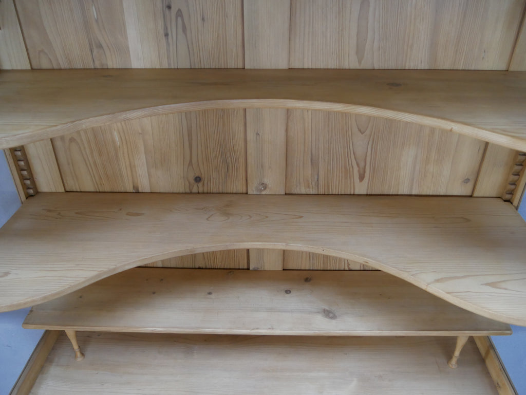 Detailaufnahme des Innenraums der antiken Bibliotheksvitrine. Sichtbar sind die originalen mundgeblasenen Glasscheiben sowie die stabilen Einlegeböden im historischen Vitrinenoberteil.