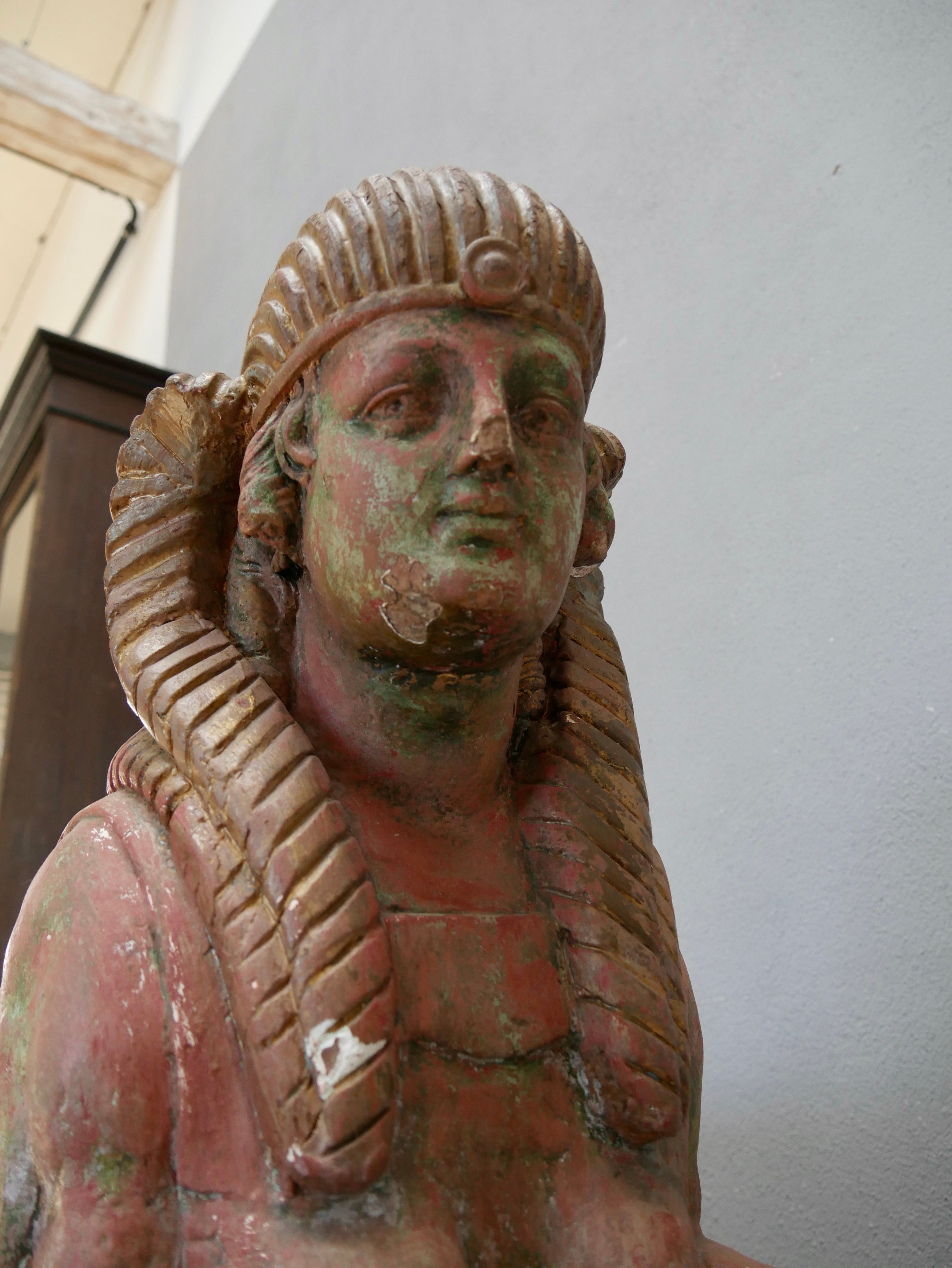 Detailaufnahme des kunstvoll gestalteten Kopfes einer antiken Sphinx. Sichtbar sind das fein ausgearbeitete Gesicht, das ägyptisch inspirierte Nemes-Kopftuch sowie die originale Farbfassung mit schöner Alterspatina.