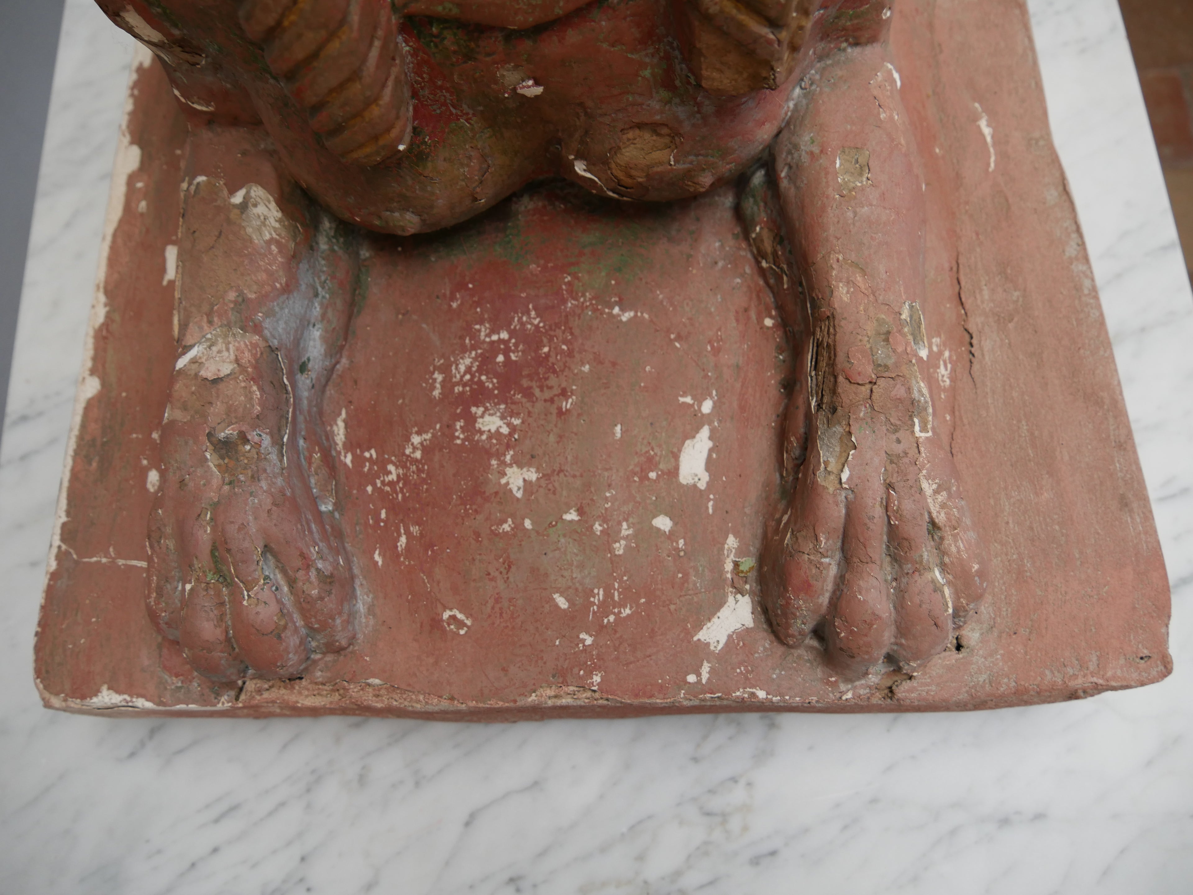 Detailaufnahme der Vorderpfote und des Sockels einer antiken Sphinx. Sichtbar sind die plastische Modellierung des Löwenkörpers sowie die gealterte Farbfassung mit kleinen Abplatzungen.