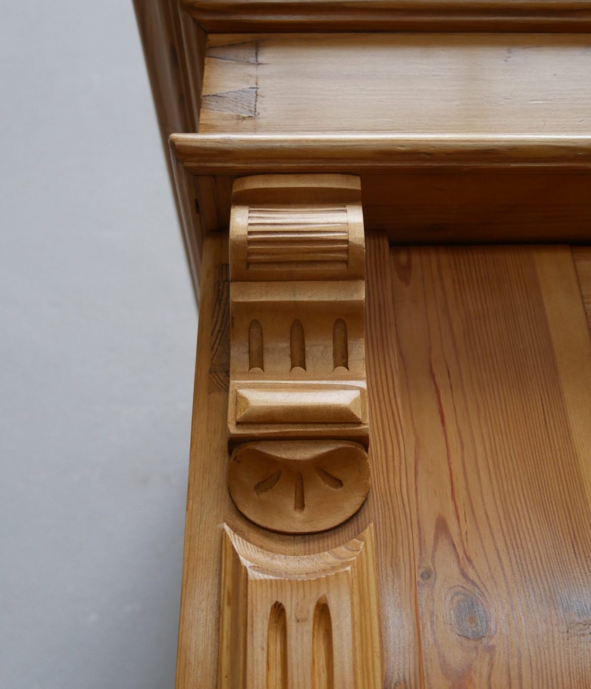 Detailaufnahme eines reich verzierten seitlichen Zierelements am Gründerzeit Kleiderschrank. Die kunstvoll gearbeitete Ornamentik zeigt die hochwertige Handwerkskunst der Epoche.