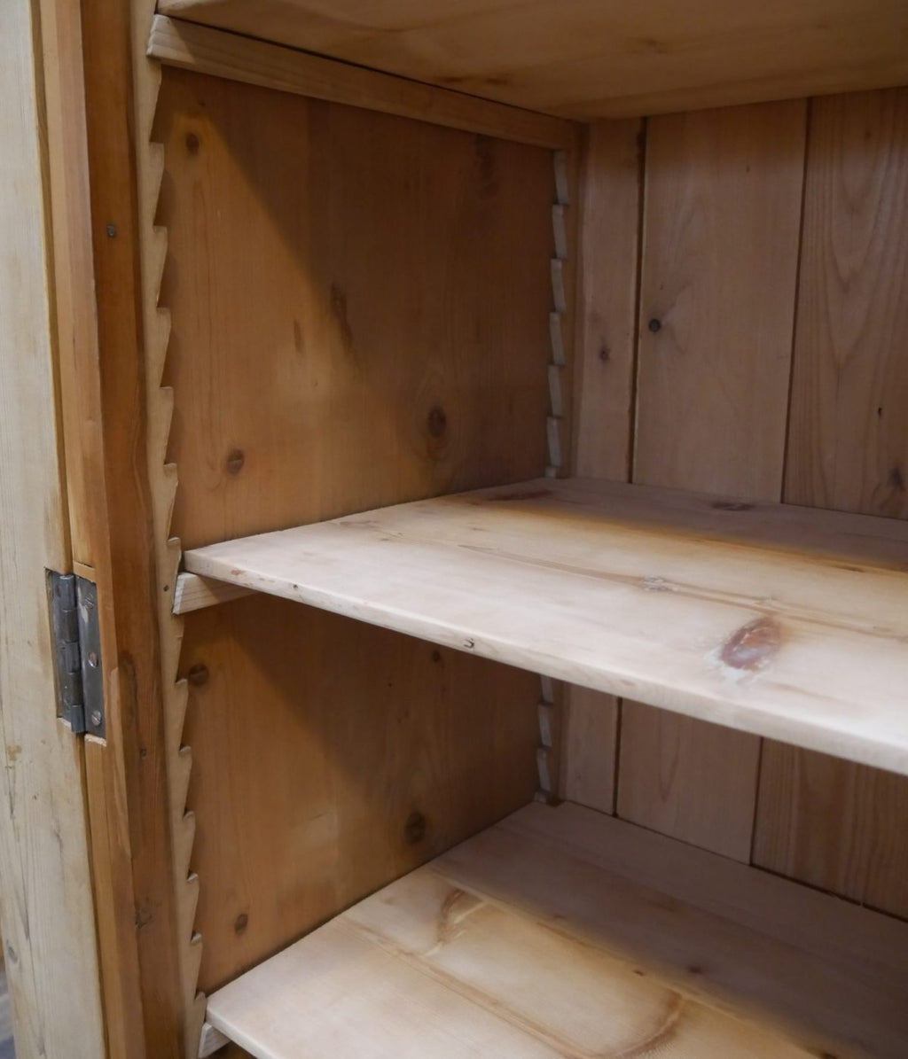 Detailaufnahme eines verstellbaren Einlegebodens im Innenraum des historischen Lehrmittelschranks. Sichtbar sind die robuste Holzausführung und das praktische Regalsystem.