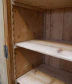 Detailaufnahme eines verstellbaren Einlegebodens im Innenraum des historischen Lehrmittelschranks. Sichtbar sind die robuste Holzausführung und das praktische Regalsystem.