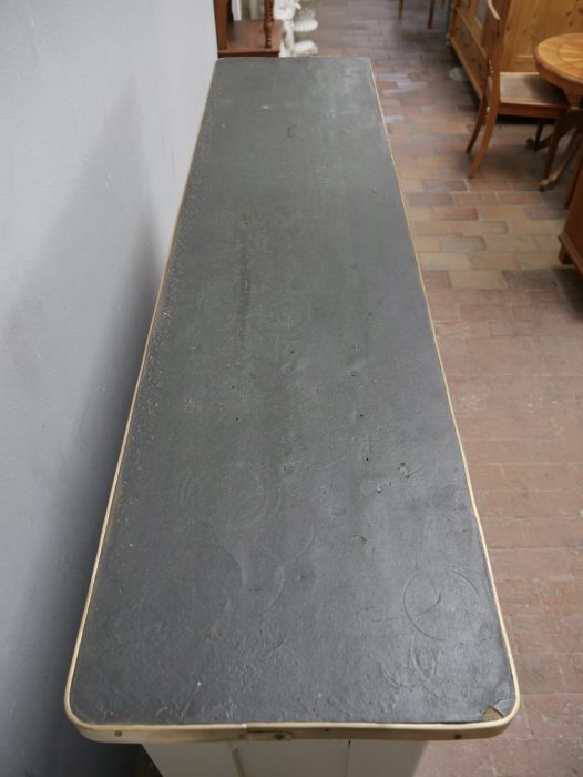 Detailansicht der massiven Holzplatte mit natürlicher Maserung auf dem weißen Sideboard.