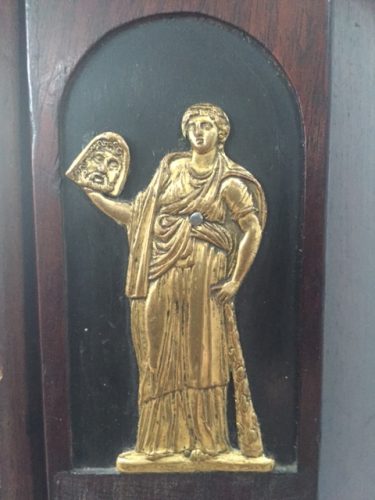 Nahaufnahme eines fein gearbeiteten feuervergoldeten Originalbeschlags mit antiker Figurenverzierung. Das hochwertige Beschlagornament ist ein typisches Gestaltungselement exklusiver Empire-Möbel.