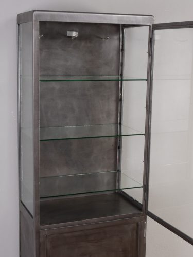 Geöffnete Glastür des antiken Arzt- und Büroschrankes mit Blick auf den Innenraum. Sichtbar sind die drei Glas-Einlegeböden sowie die höhenverstellbaren Auflagen, die eine flexible Nutzung als Vitrinen-, Praxis- oder Büroschrank ermöglichen.
