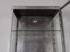 Detailaufnahme des oberen Innenraums des restaurierten Vitrinenschrankes. Die stabilen Glas-Einlegeböden, die saubere Restaurierung und die mehrfach höhenverstellbaren Bodenträger verdeutlichen die hochwertige Verarbeitung des historischen Industrieschrankes.
