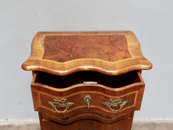 Geöffnete obere Schreib- bzw. Klappplatte der Barock-Pfeilerkommode. Die geschwungene Platte mit edlen Intarsien und fein gearbeiteten Profilen zeigt die hochwertige handwerkliche Verarbeitung des historischen Möbelstücks.
