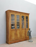 Gesamtansicht des großen originalen Biedermeier Bibliotheksschranks im außergewöhnlich unberührten Originalzustand. Der elegante Bücherschrank besitzt vier verglaste Türen mit Originalglas, eine originale Bierlasur sowie originale Schlösser und Schlüssel. Der Schrank ist komplett zerlegbar und eignet sich ideal als hochwertige Bibliothek oder Vitrinenschrank.
