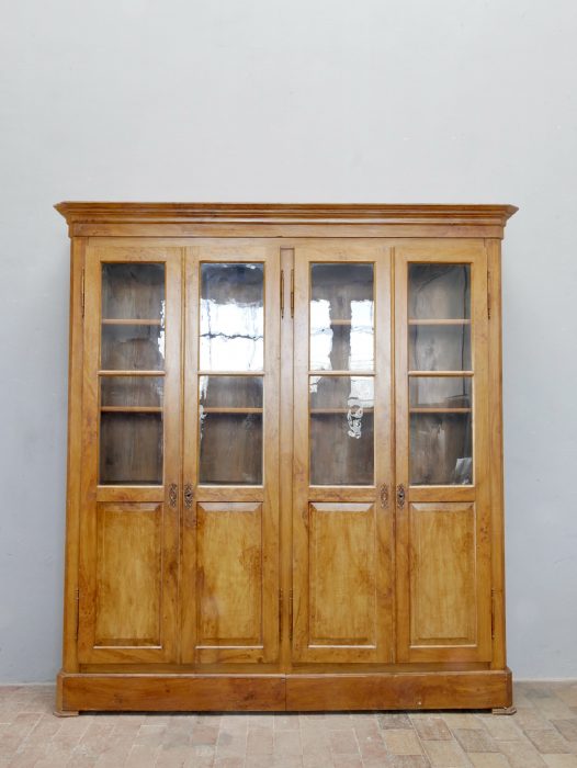 Frontalansicht des geschlossenen Biedermeier Bücherschranks. Die symmetrische Gestaltung mit vier Glastüren und klassischer Linienführung macht dieses Möbel zu einem beeindruckenden Original des Biedermeiers.
