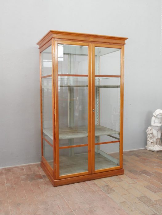 Schräg aufgenommene rechte Seitenansicht des seltenen Lehrmittelschranks der Firma Max Kohl Chemnitz aus der Zeit um 1920. Die Aufnahme zeigt die hohen originalen Glasscheiben, den schlanken Holzrahmen, das profilierte obere Gesims und den geschlossenen Sockel der historischen Vitrine.