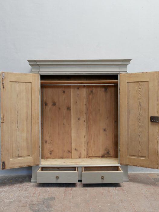 Empire Kleiderschrank mit vollständig geöffneten Türen. Sichtbar sind das großzügige Innenleben mit Kleiderstange, Ablagebrett sowie die beiden großen unteren Schubladen.