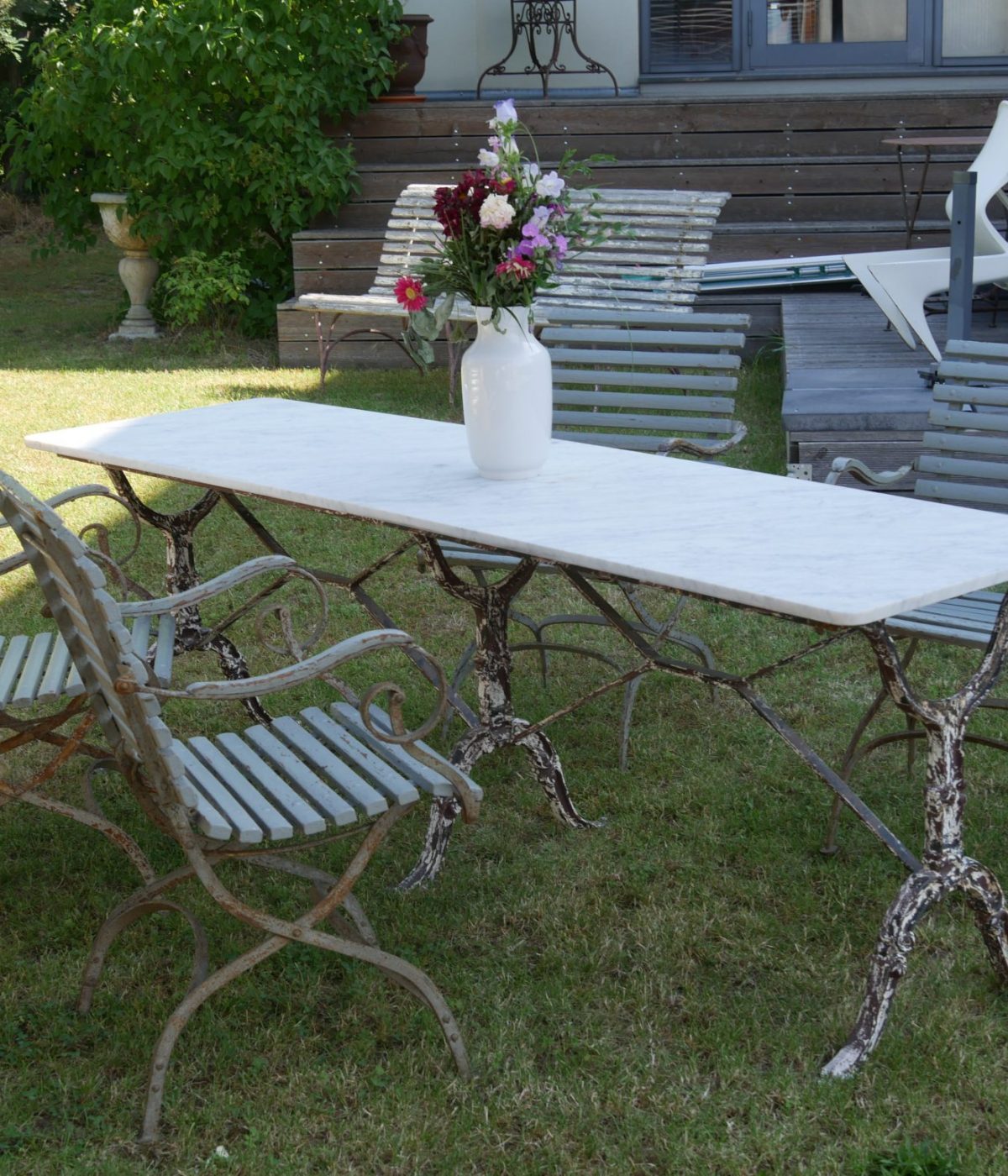 Französischer Gartentisch mit weißer Marmorplatte und kunstvoll verziertem Eisengestell um 1920–1940 in der Gesamtansicht.
