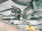 Detailansicht eines handgeschmiedeten Blatt- und Rankenornaments des historischen Geländers. Die plastische Ausarbeitung, feinen Hammerschläge und originale Patina verdeutlichen die meisterhafte Schmiedekunst des 19. Jahrhunderts.
