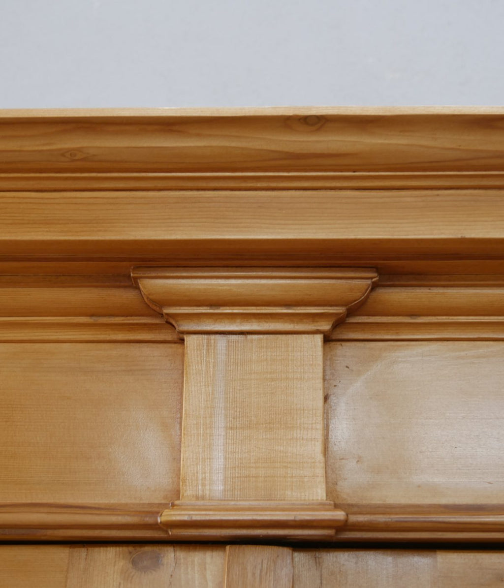 Detailansicht eines kunstvoll profilierten Gesimselements unterhalb der Kranzleiste. Die fein ausgearbeiteten Profile sind typisch für hochwertige Gründerzeitmöbel und betonen die elegante Gestaltung.