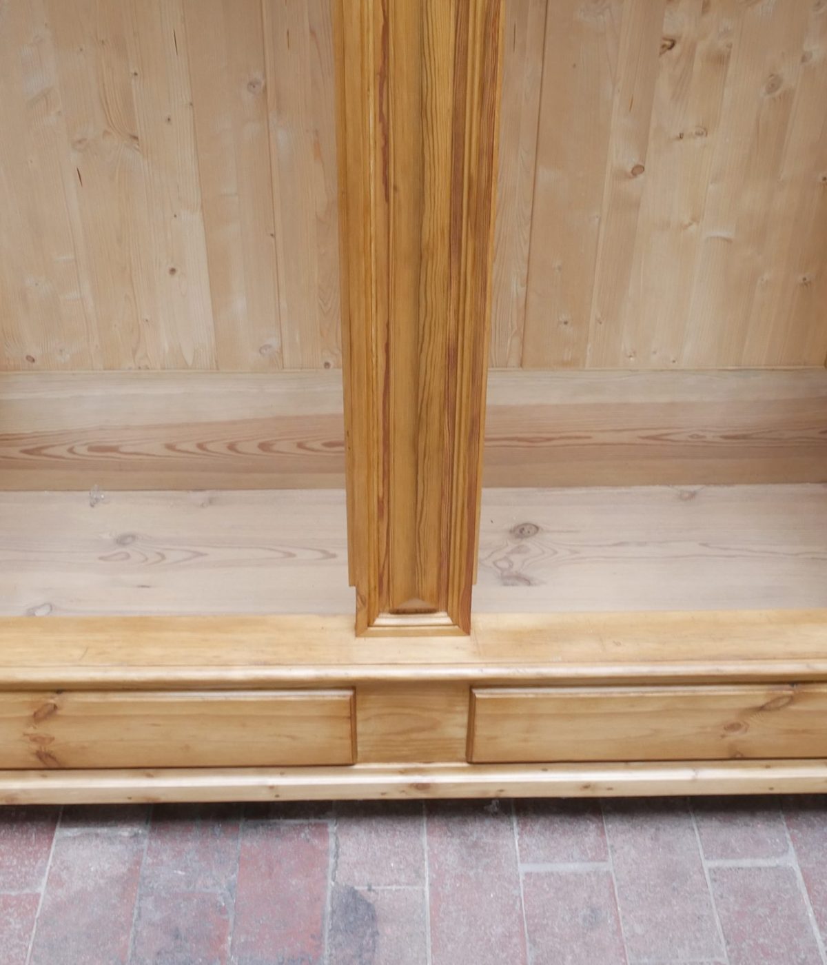 Detailaufnahme des unteren Innenbereichs mit stabiler Holzkonstruktion. Die hochwertige Innenausstattung des restaurierten Gründerzeit Schranks ist deutlich sichtbar