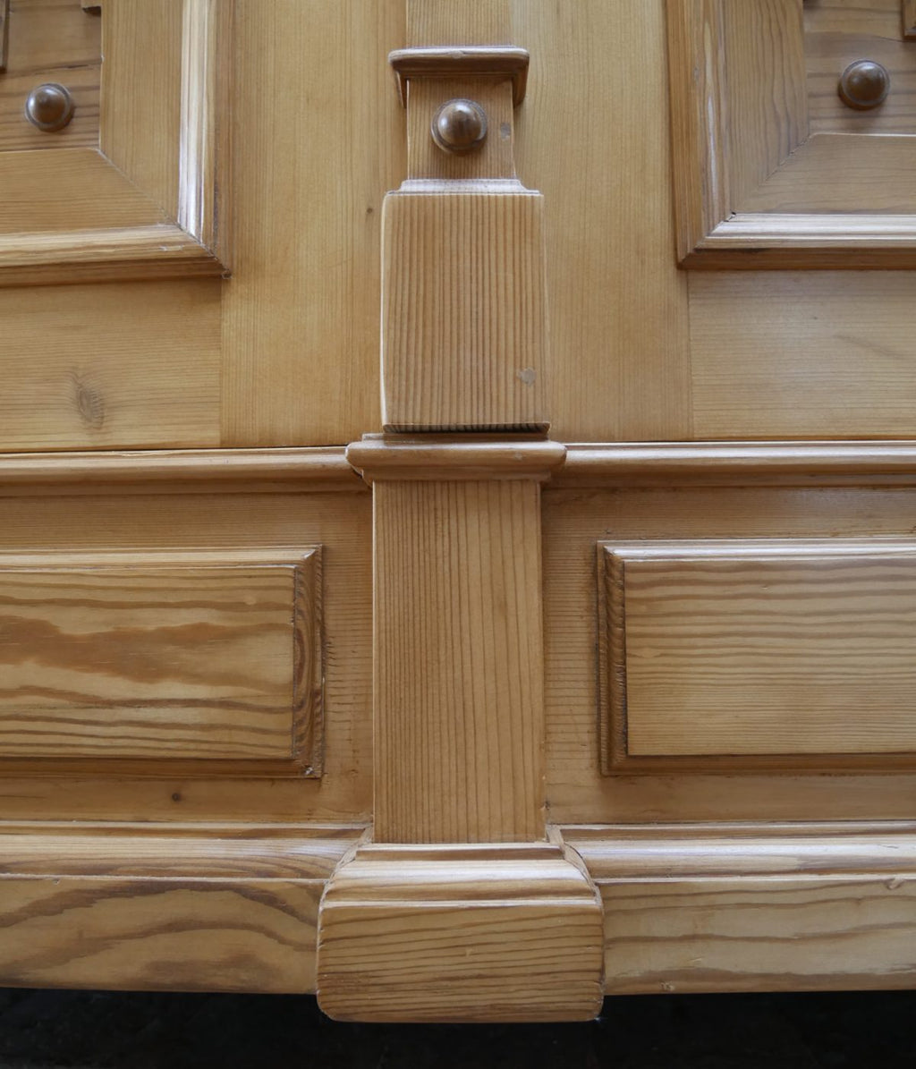 Nahaufnahme eines profilierten Rahmen- und Gesimselements am Schrank. Sichtbar sind die präzise ausgeführten Übergänge sowie die sorgfältige handwerkliche Verarbeitung des Weichholzes.