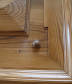 Detailaufnahme einer profilierten Türfüllung mit umlaufenden Zierleisten. Die hochwertige Kassettentür und die natürliche Holzmaserung zeigen die außergewöhnlich aufwendige Gestaltung dieses originalen Gründerzeit-Kleiderschranks aus der Zeit um 1880.