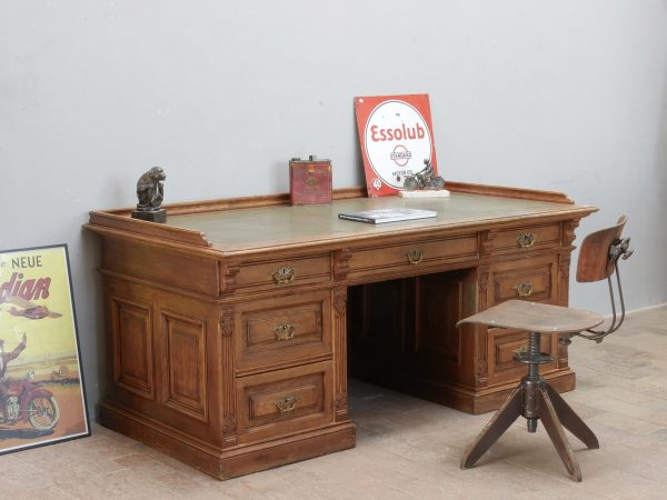 Beeindruckender Kontorschreibtisch beziehungsweise Sekretär aus der Gründerzeit um 1900 aus mittlerer Eiche. Die großzügige Schreibfläche mit geprägtem grünem Leder, die aufwendig gestalteten Schubladen und die umlaufende Kassettierung machen dieses historische Möbel zu einem außergewöhnlichen Blickfang, der frei im Raum aufgestellt werden kann.