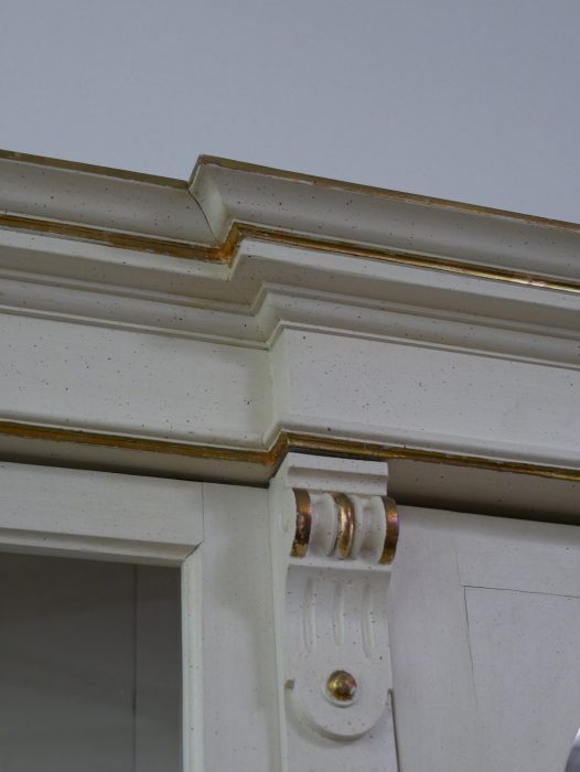 Nahaufnahme der profilierten Kranzleiste mit klassischen Gründerzeit-Profilen und fein ausgearbeiteten Übergängen zwischen Oberteil und Gesims.