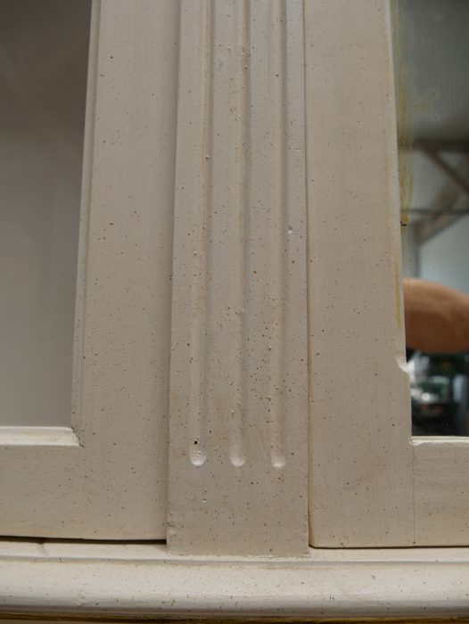 Detailaufnahme einer originalen vertikal profilierten Schiebetür mit klassischer Gründerzeit-Oberfläche und fein ausgearbeiteten Holzprofilen.