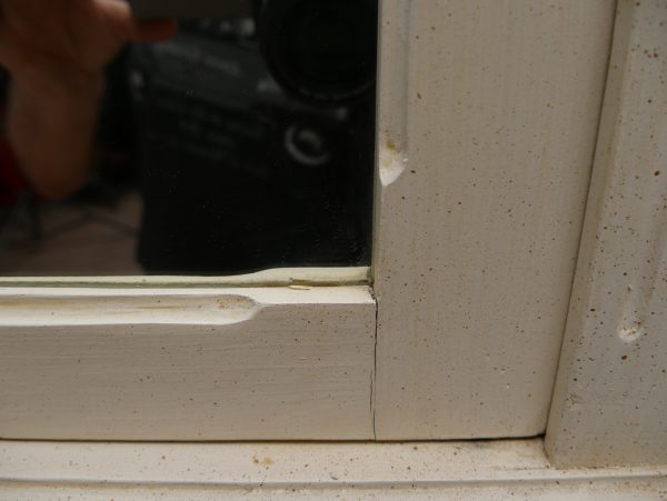 Detailaufnahme des Rahmens um das originale Spiegelglas mit fein profilierten Leisten und historischer Oberflächenstruktur.