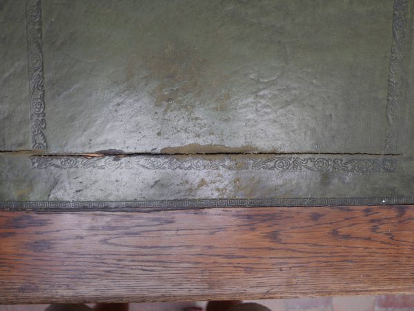 Detailansicht der originalen Schreibfläche mit geprägtem Leder und sichtbarer Teilung der Lederfelder. Die Aufnahme dokumentiert den authentischen Originalzustand der historischen Schreibplatte.