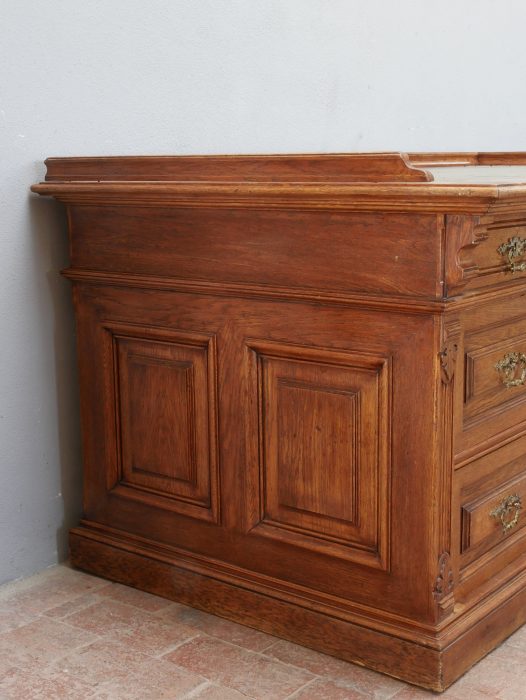 Seitenansicht des historischen Kontorschreibtisches. Die umlaufende Kassettierung auf der Rückseite ermöglicht eine freie Platzierung des Möbels im Raum und unterstreicht die hochwertige Verarbeitung.