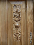 Detailaufnahme einer aufwendig geschnitzten Türfüllung des restaurierten Gründerzeit-Vertikos. Die dekorative Holzschnitzerei zeigt charakteristische florale und ornamentale Formen der Gründerzeit. Die warme Weichholzoberfläche, die plastische Schnitzarbeit und die handwerkliche Ausführung sind in dieser Nahaufnahme besonders gut erkennbar.