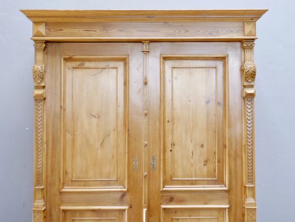 Detailaufnahme des oberen Frontbereiches mit der profilierten Kranzleiste sowie den oberen Türfüllungen. Die Aufnahme zeigt die hochwertige Verarbeitung und die harmonischen Proportionen des Gründerzeit-Möbels.