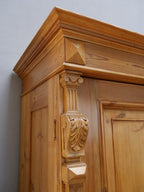 Nahaufnahme des linken geschnitzten Eckpilasters mit aufwendig gearbeiteten Gründerzeit-Ornamenten. Sichtbar sind florale Schnitzereien und fein profilierte Kapitelle.