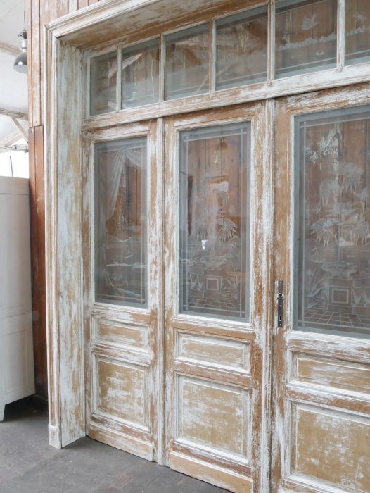 Detailaufnahme des rechten Bereichs der historischen Tueranlage mit den aufwendig gestalteten Türfüllungen und den satinierten Glasscheiben im Jugendstil.