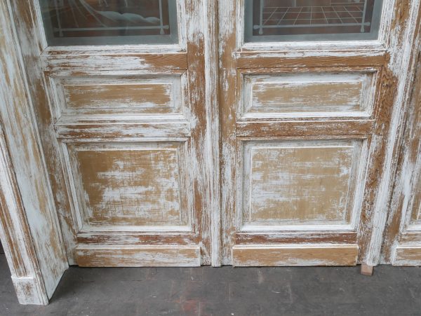 Detailaufnahme des unteren Türbereichs der historischen Tueranlage. Gut sichtbar sind die originalen Holzfüllungen, die gealterte Oberfläche und die authentische Patina des Jugendstil-Holzes.