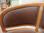 Nahaufnahme der geschwungenen Rückenlehne mit originalem Lederbezug und dekorativer Nagelung. Das Detail zeigt die hochwertige handwerkliche Verarbeitung der Armlehnsessel.