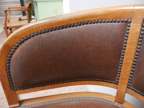 Nahaufnahme der geschwungenen Rückenlehne mit originalem Lederbezug und dekorativer Nagelung. Das Detail zeigt die hochwertige handwerkliche Verarbeitung der Armlehnsessel.