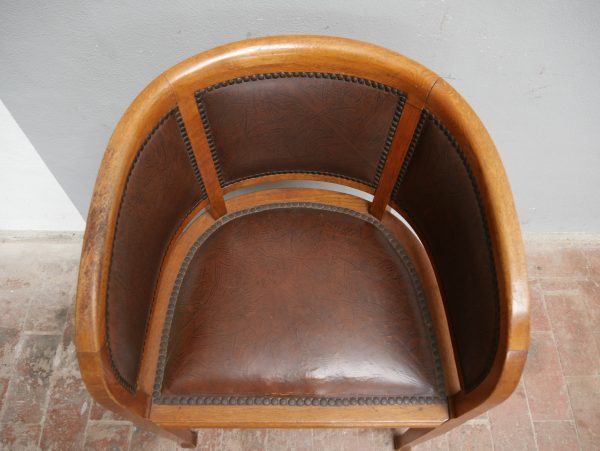 Blick von oben in die gerundete Sitzschale eines originalen Jugendstil Armlehnsessels. Sichtbar sind die ergonomische Form sowie der originale Lederbezug mit schöner Patina.