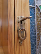 Detailaufnahme des originalen Türbeschlags mit Schlüsselschild und Griff. Der vollständig erhaltene Originalbeschlag ergänzt die hochwertige Ausstattung des seltenen Jugendstil-Vertikos.