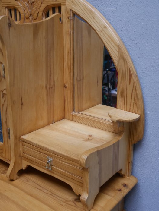 Detailaufnahme eines seitlichen offenen Ablagefaches des Aufsatzes. Die geschwungene Konstruktion und die harmonische Linienführung unterstreichen die hochwertige Gestaltung des Möbelstücks.
