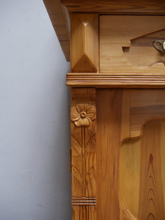 Detailaufnahme der seitlichen Jugendstil-Schnitzerei am Aufsatz. Die fein ausgearbeiteten floralen Ornamente verdeutlichen den außergewöhnlich hohen handwerklichen Aufwand dieses Einzelstücks.