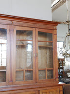 Detailansicht der verglasten Front des originalen Jugendstil-Bibliotheksschranks. Sichtbar sind die hochwertigen Holzrahmen, das originale Glas und die handwerklich präzise Verarbeitung.