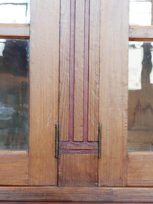 Detailaufnahme eines senkrechten profilierten Pilasters an der Front der originalen Jugendstil-Bibliothek um 1910. Die schmale Holzleiste besitzt eine vertiefte rechteckige Gliederung und zeigt die präzise handwerkliche Ausführung sowie die schön erhaltene Oberflächenpatina des historischen Laden- und Vitrinenschranks.