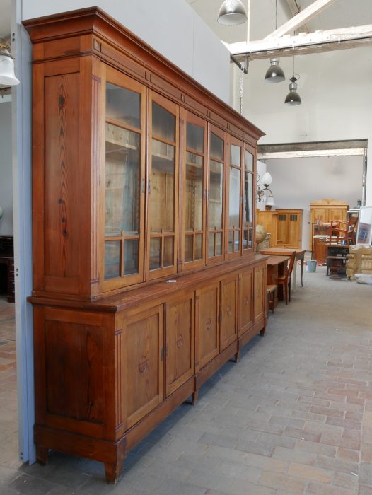 Linke Seitenansicht des großen Jugendstil-Ladenschranks mit originaler Oberflächenpatina. Die Aufnahme zeigt die Tiefe des Möbels und den hochwertigen massiven Aufbau des zweiteiligen Bibliotheksschranks.