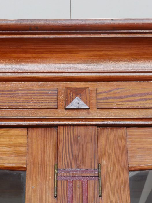 Detailaufnahme eines originalen Beschlags an der Front des Jugendstil-Bibliotheksschranks. Die historischen Metallbeschläge sind vollständig erhalten und tragen wesentlich zum authentischen Erscheinungsbild bei.
