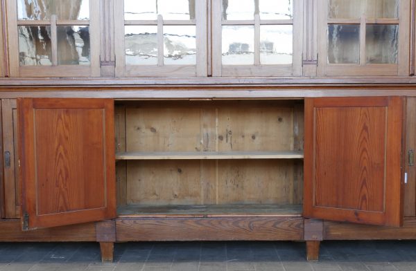 Geöffneter Unterschrank der originalen Jugendstil-Bibliothek. Die Aufnahme zeigt den geräumigen Innenraum und die praktische Aufteilung des unteren Stauraumbereichs.
