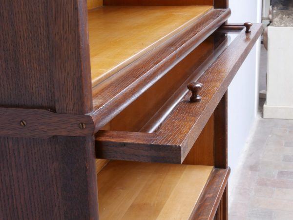 Detail des ausziehbaren Elementeinsatzes des Bookcase-Bücherschranks. Die Aufnahme zeigt die präzise gearbeitete Konstruktion und die funktionale Ausführung des historischen Systemmöbels aus Eiche.
