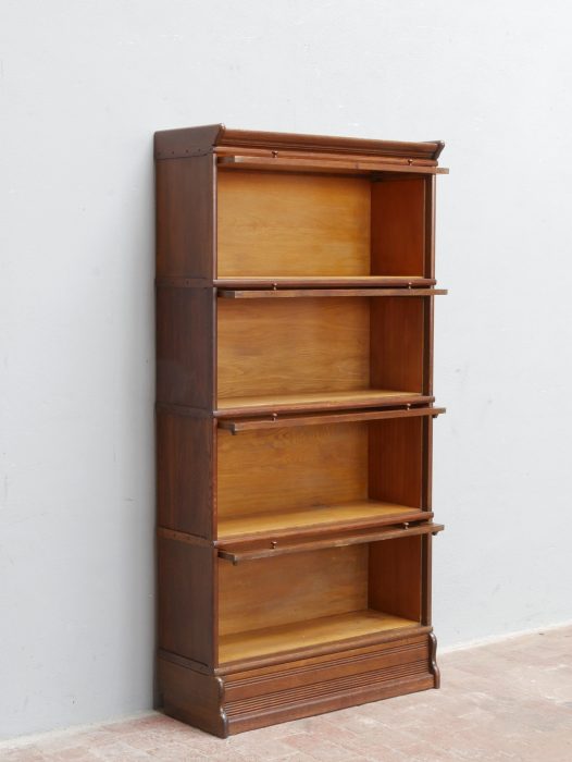Frontalansicht des geöffneten Bookcase-Bücherschranks mit den geräumigen Regalfächern. Die stapelbare Konstruktion bietet viel Stauraum für Bücher und Sammlerstücke und zeigt die praktische Systembauweise der Zeit um 1910.
