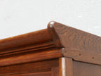Detailaufnahme des profilierten Kranzgesimses des originalen Jugendstil-Bookcase-Bücherschranks. Das fein gearbeitete Profil und die geölte Eichenoberfläche unterstreichen die hochwertige Qualität des historischen Bibliotheksmöbels.
